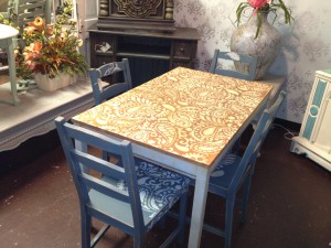 Blue distressed chairs with light wood stained table both done in paisley stencil.